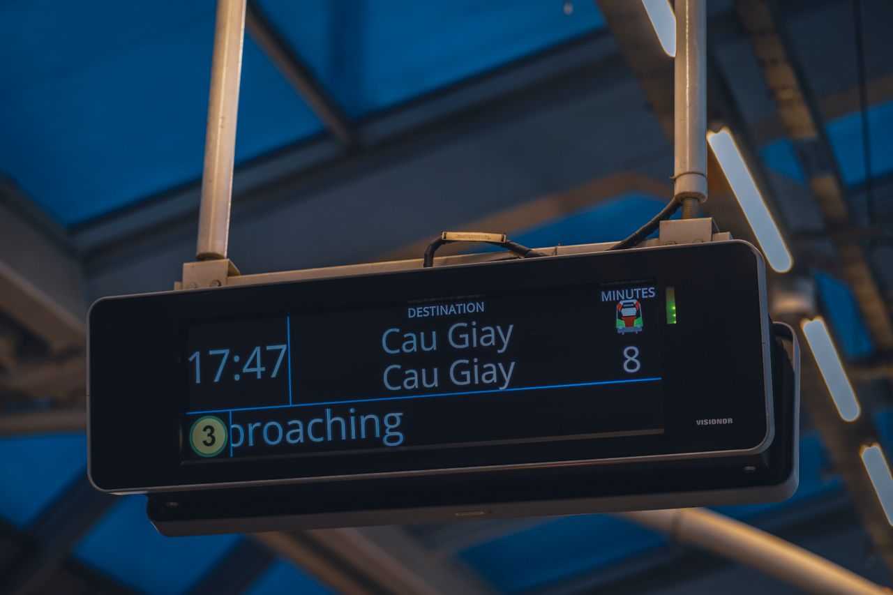 Digital train station sign showing destination and minutes at Cau Giay.