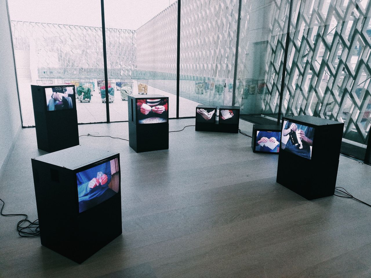 Explore a modern art exhibit with multiple screens displaying digital art in a sleek museum setting.